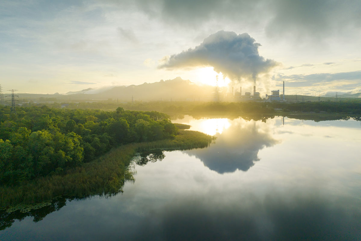 Aerial view of factory and emissions in green area