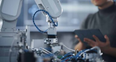 Robotic arm and employee working on innovation