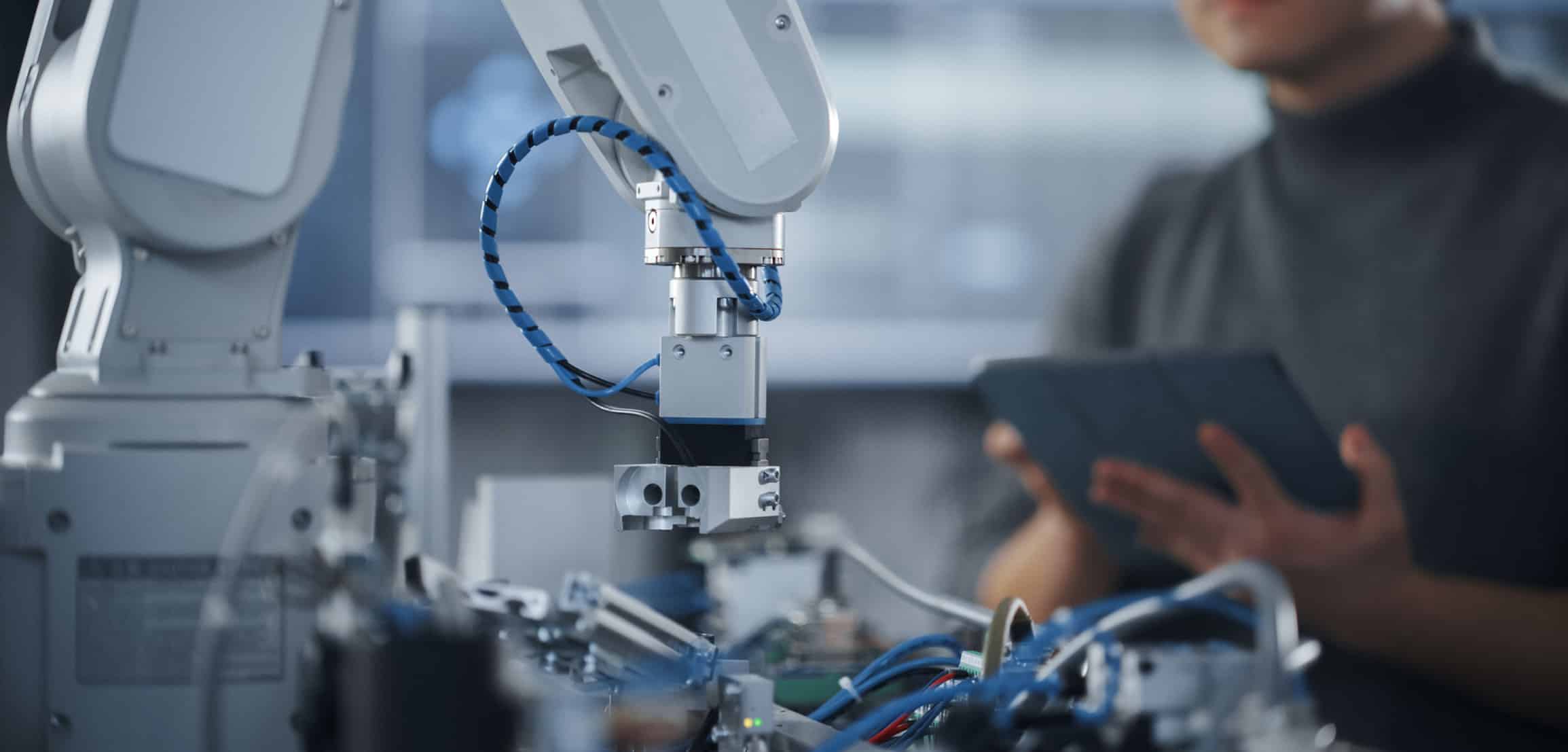 Robotic arm and employee working on innovation